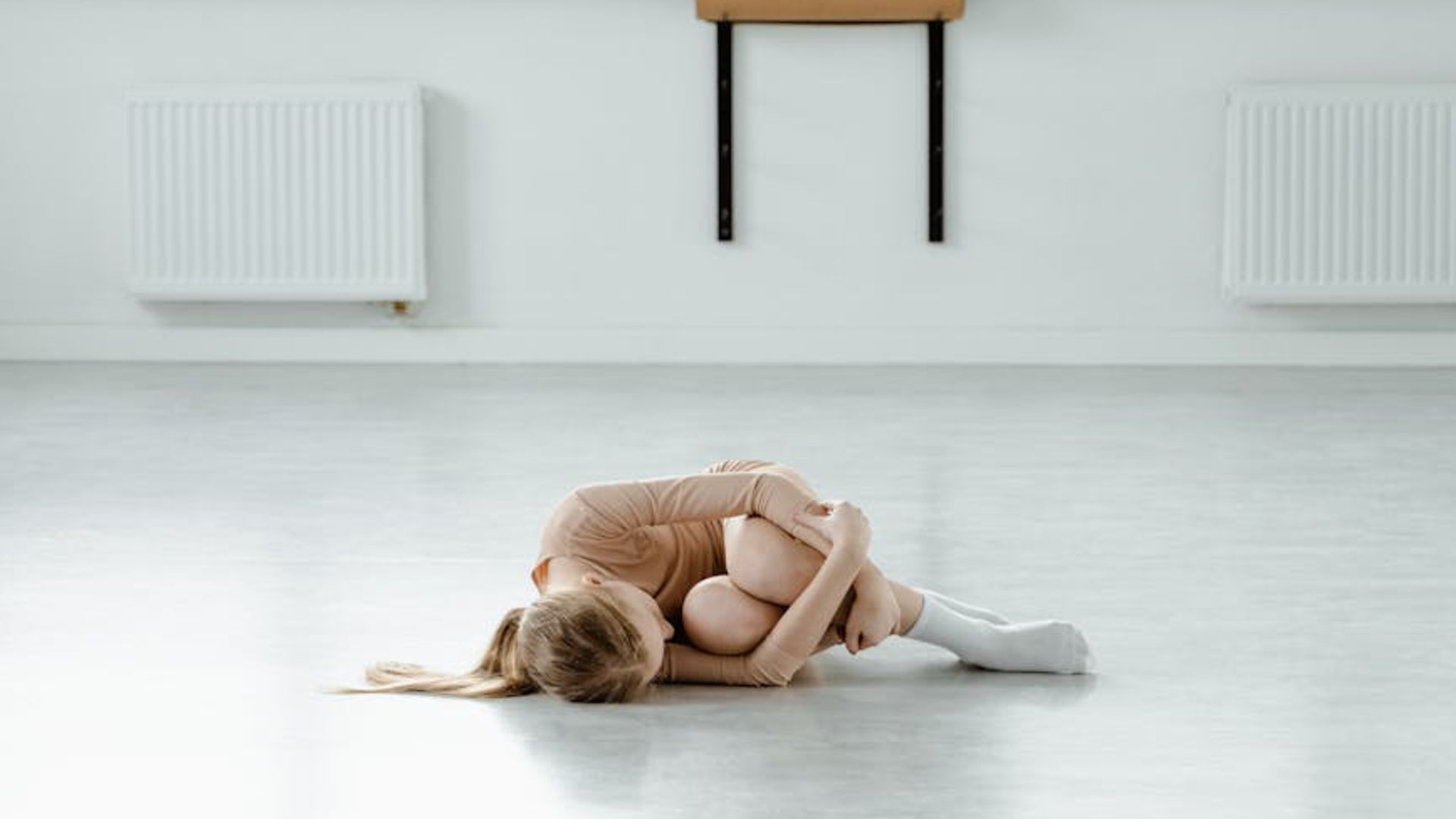 Minimalist bright yoga studio with wooden floor and large windows